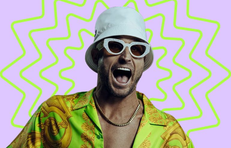 A man in a white bucket hat yelling playfully against a colorful background